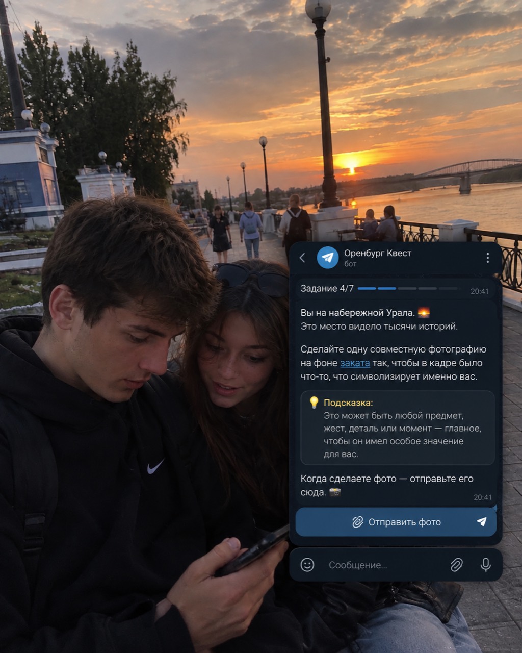 Молодой человек и девушка читают задание Telegram-квеста на набережной Урала на закате